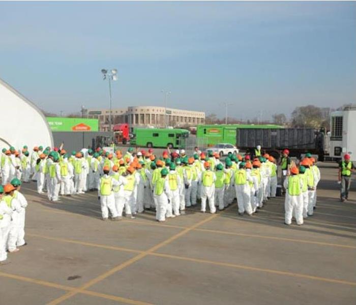 Photo is showing a large crew of SERVPRO Technicians suited up in PPE Gear ready to assist in a large water loss