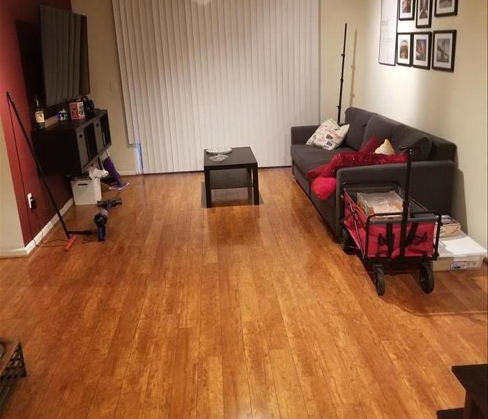 Photo is showing a living room with brown laminate floor