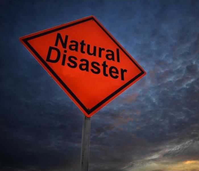 Photo is showing a red street sign that says Natural Disaster